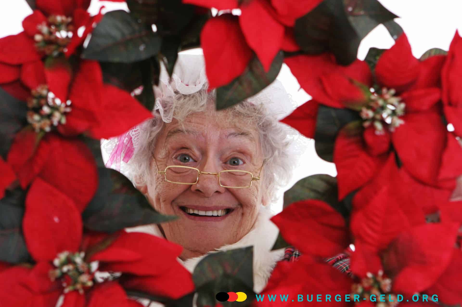 Ältere Dame hinter Weihnachtsblumen