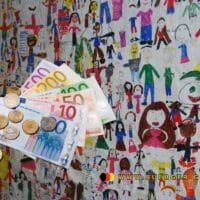 Euro vor einer von Kindern bemalten Wand